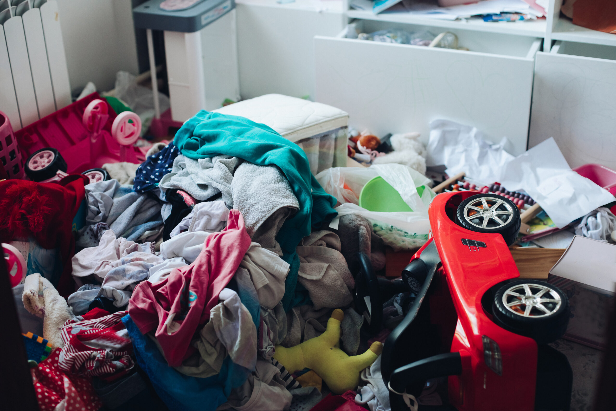Unordentliches Zimmer mit verstreuten Gegenständen vor der Entrümpelung